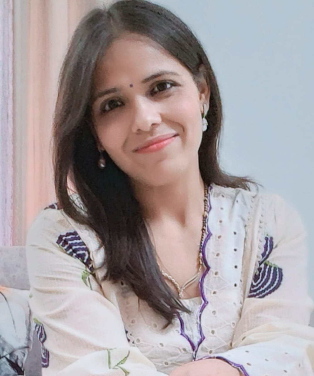 Portrait of Dr. Kapoor wearing traditional attire with academic books in background